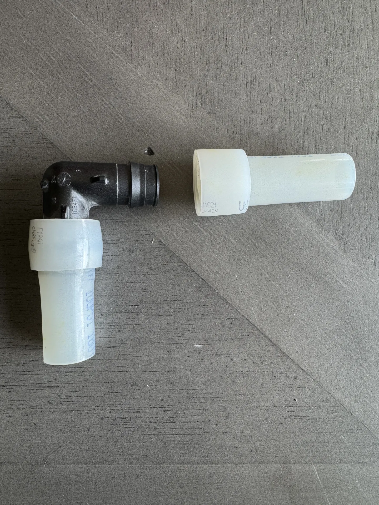 Close-up of a ProPEX elbow fitting with the PEX pipe separated from it, no cracking or damage visible at the joint.